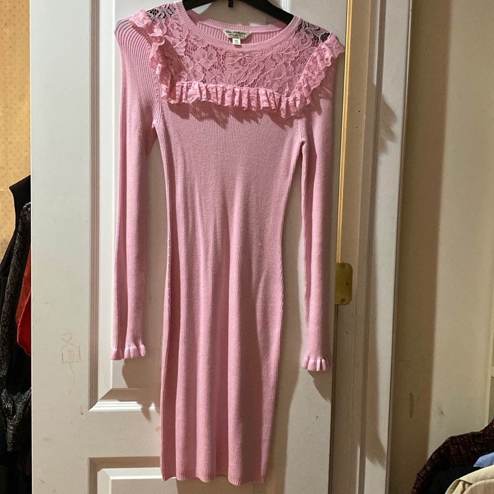 Pink knitted mini dress with lace ruffling by the chest.